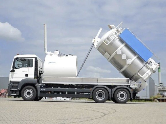 Industrial vacuum truck with tank tipped for discharge