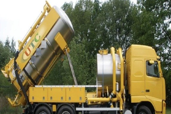 Yellow UTC vacuum truck with cyclone tank tipped